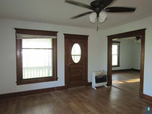 foyer featuring heating unit, a ceiling fan, crown molding, baseboards, and wood finished floors