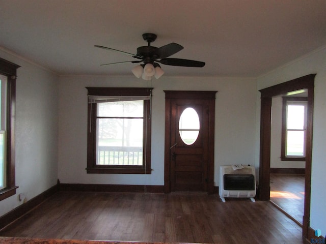 entrance foyer featuring heating unit, plenty of natural light, dark wood-type flooring, ceiling fan, and crown molding
