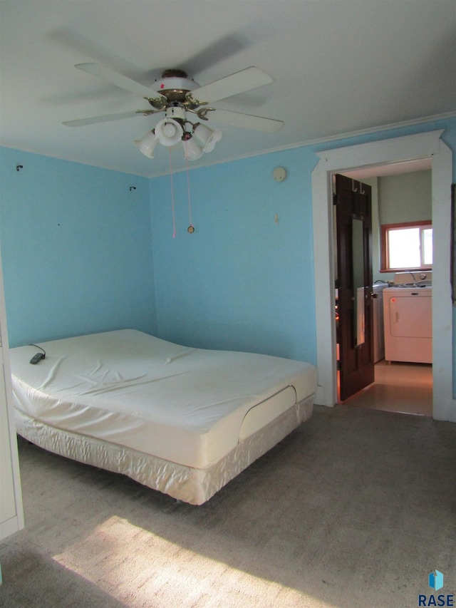 bedroom with carpet floors, washer and dryer, and ceiling fan