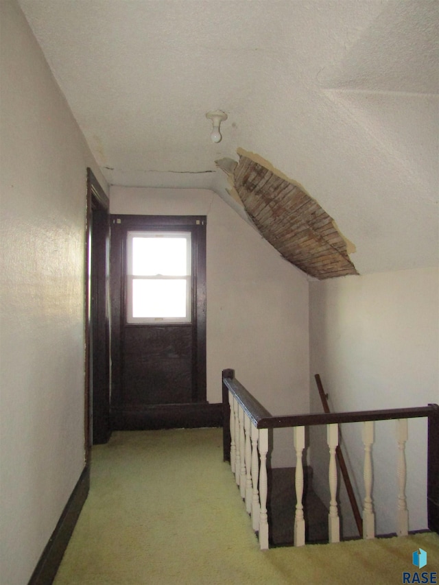 bonus room with light colored carpet, lofted ceiling, and a textured ceiling