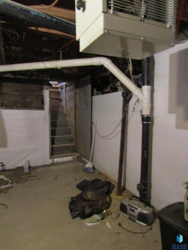 below grade area featuring stairs and a heating unit