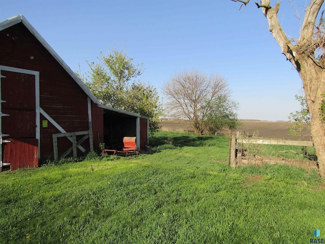 view of green lawn with an outdoor structure and a barn