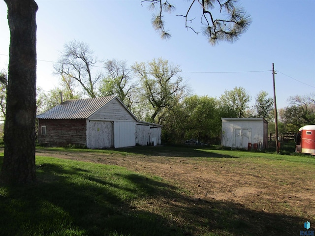 view of grassy yard with an outdoor structure