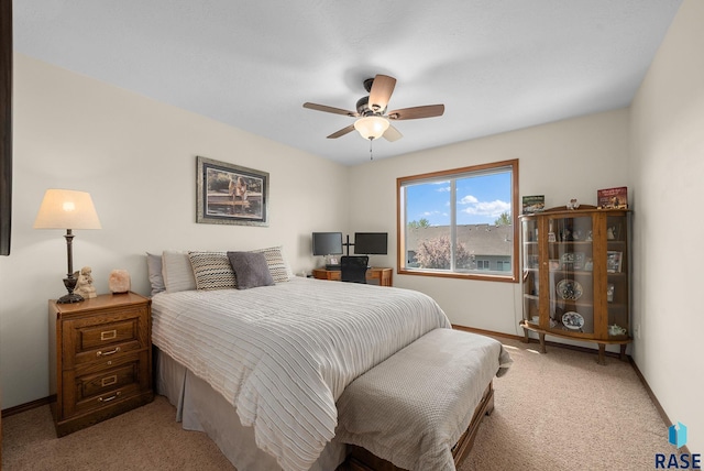 bedroom featuring light colored carpet, baseboards, and ceiling fan