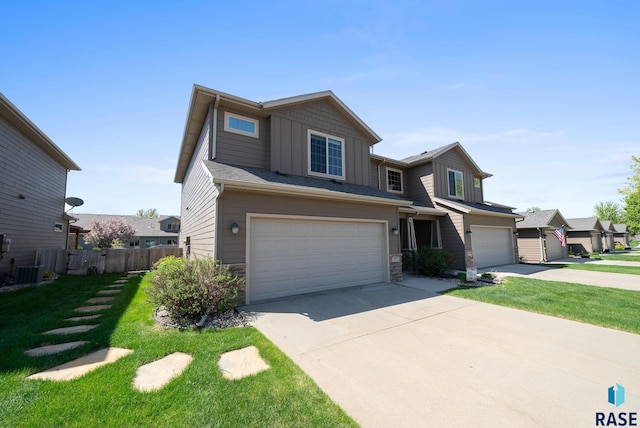view of front of house with board and batten siding, a garage, stone siding, and driveway