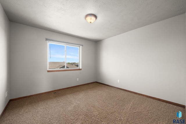 empty room featuring carpet floors and baseboards
