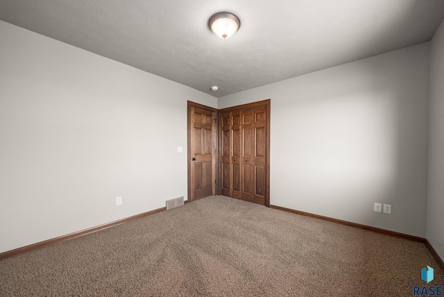 carpeted empty room with baseboards