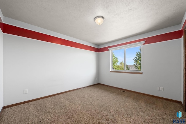 carpeted spare room with baseboards and a textured ceiling