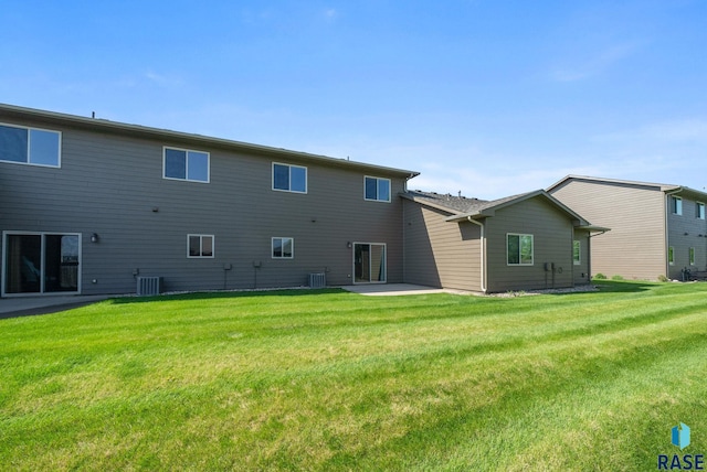 rear view of property featuring a lawn, a patio, and central air condition unit