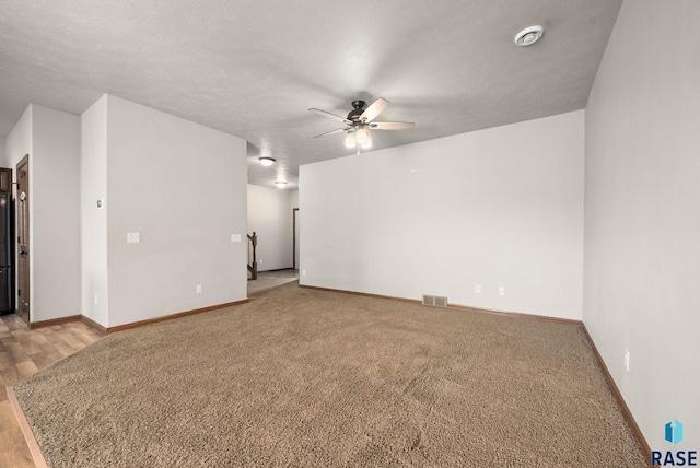 unfurnished room with a ceiling fan, baseboards, and carpet flooring