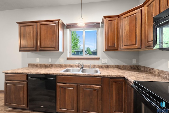 kitchen featuring black appliances, a sink, and decorative light fixtures