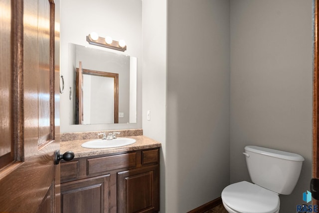 half bathroom featuring vanity and toilet