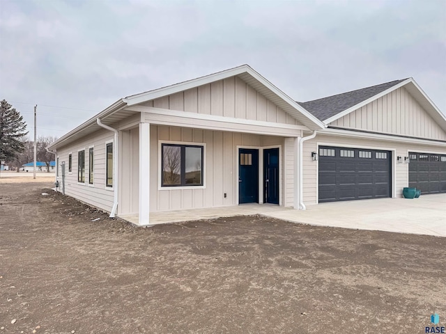 view of front of property featuring board and batten siding, a garage, and concrete driveway