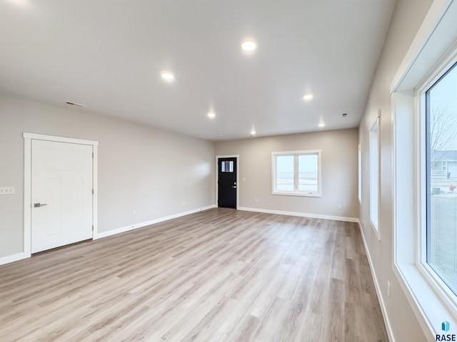 unfurnished living room with light wood-type flooring, baseboards, and recessed lighting