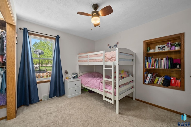 bedroom with carpet, a ceiling fan, a textured ceiling, and baseboards