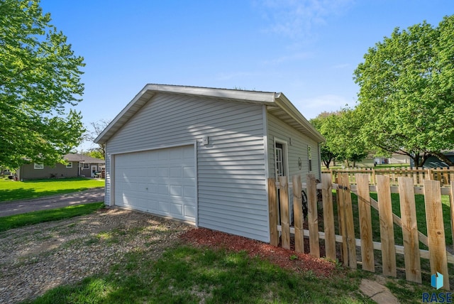detached garage featuring fence