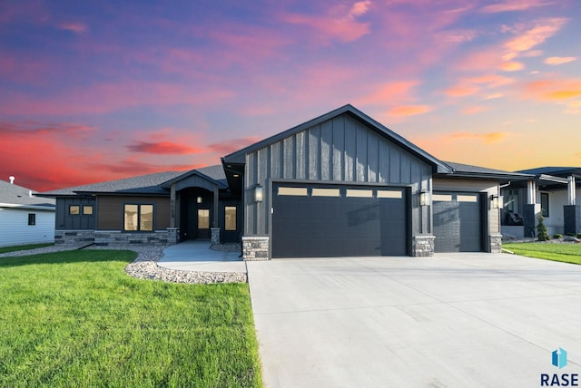 6609 E Corsair Dr, Sioux Falls, SD 57110 - view of front of home featuring an attached garage, board and batten siding, stone siding, and a front lawn