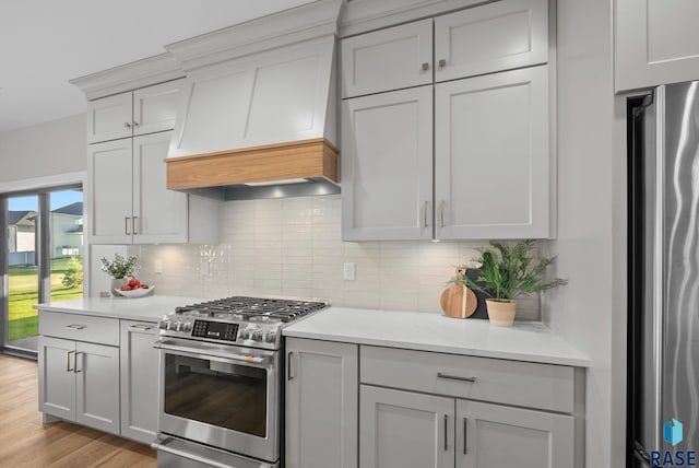 6609 E Corsair Dr, Sioux Falls, SD 57110 - kitchen with stainless steel appliances, custom exhaust hood, light wood finished floors, and decorative backsplash