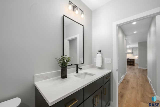 6609 E Corsair Dr, Sioux Falls, SD 57110 - half bath featuring hardwood / wood-style flooring, recessed lighting, baseboards, vanity, and toilet