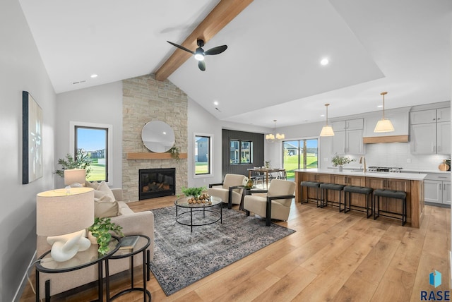 6609 E Corsair Dr, Sioux Falls, SD 57110 - living room with beamed ceiling, ceiling fan, light wood-style floors, a stone fireplace, and recessed lighting