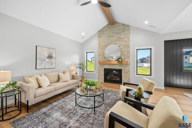 6609 E Corsair Dr, Sioux Falls, SD 57110 - living area featuring beam ceiling, wood finished floors, a ceiling fan, a stone fireplace, and baseboards