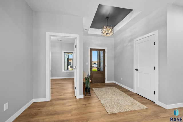 6609 E Corsair Dr, Sioux Falls, SD 57110 - foyer featuring a chandelier, baseboards, wood finished floors, and a raised ceiling