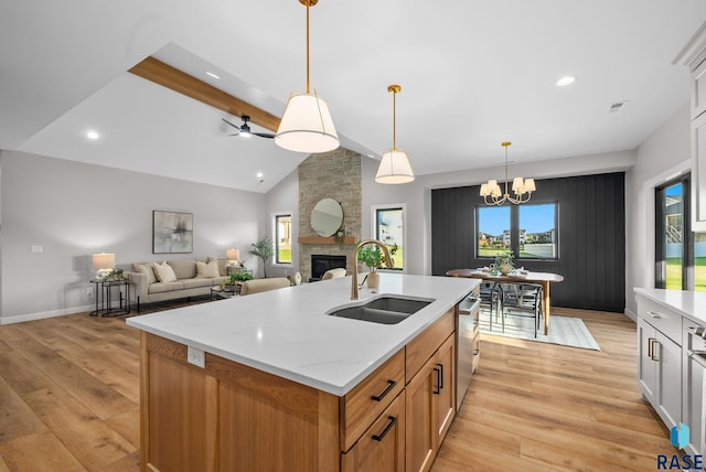 6609 E Corsair Dr, Sioux Falls, SD 57110 - kitchen featuring a sink, light wood finished floors, a stone fireplace, healthy amount of natural light, and recessed lighting