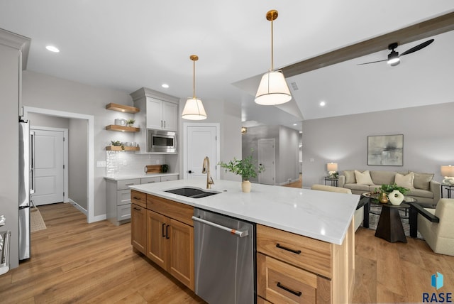 6609 E Corsair Dr, Sioux Falls, SD 57110 - kitchen featuring appliances with stainless steel finishes, a sink, open floor plan, open shelves, and light wood finished floors