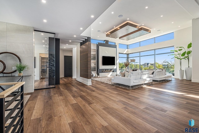 living area with wood finished floors, baseboards, and recessed lighting