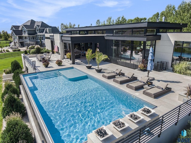 outdoor pool featuring a fire pit, a patio area, and fence