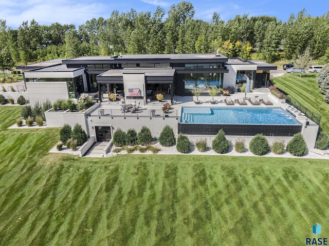 rear view of house featuring a lawn and a patio