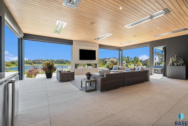 living room featuring wood ceiling, tile patterned floors, and healthy amount of natural light