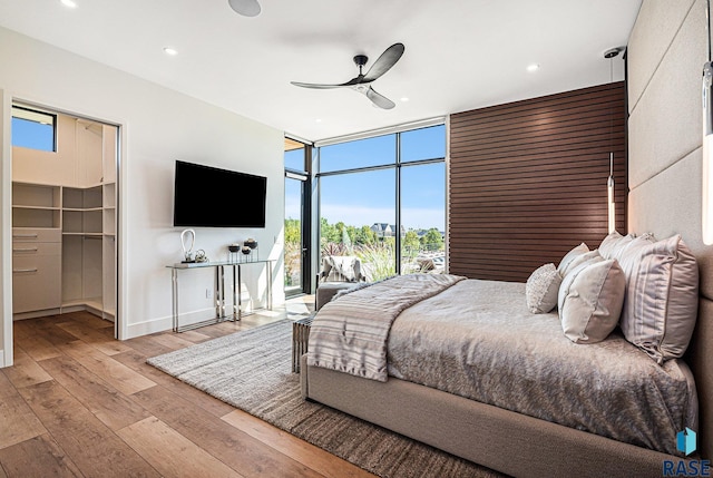 bedroom featuring multiple windows, hardwood / wood-style flooring, access to outside, expansive windows, and recessed lighting