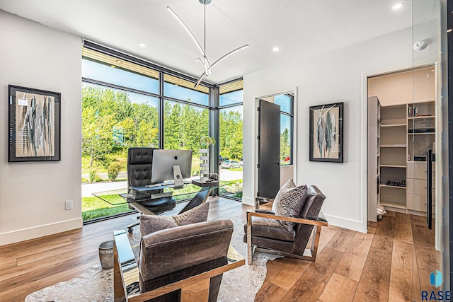 home office with floor to ceiling windows, baseboards, hardwood / wood-style flooring, and recessed lighting