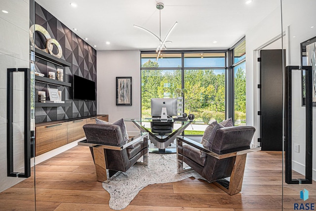 living room with light wood-type flooring, an office area, recessed lighting, and floor to ceiling windows