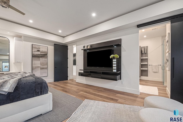 bedroom with wood finished floors, recessed lighting, baseboards, and connected bathroom