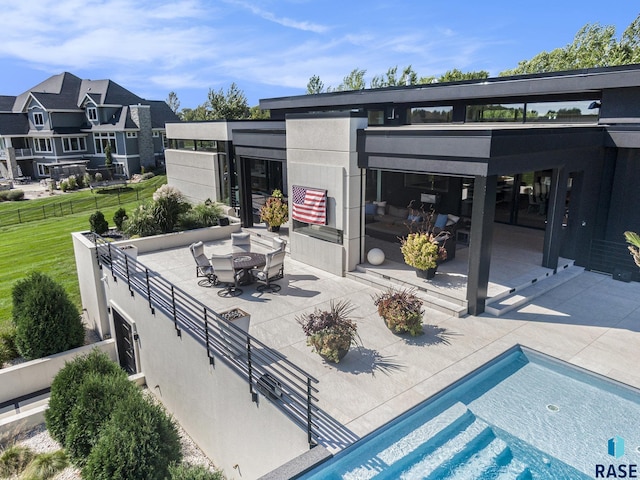 view of patio / terrace featuring fence, outdoor dining space, and an outdoor pool