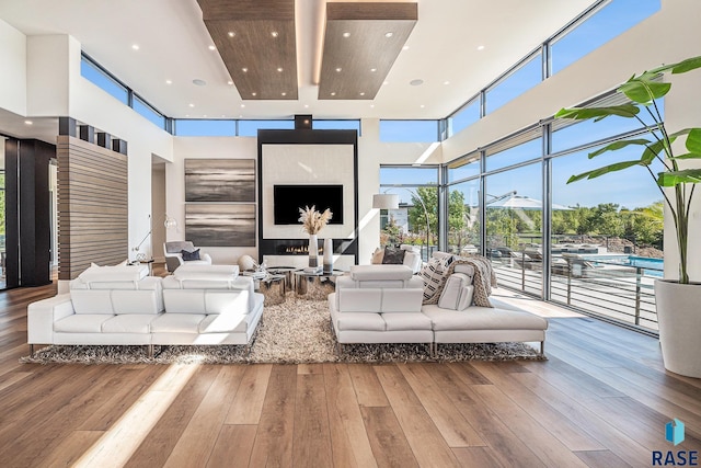 living room with recessed lighting, a high ceiling, and hardwood / wood-style floors