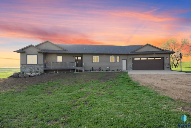 ranch-style house with stone siding, a yard, dirt driveway, and an attached garage
