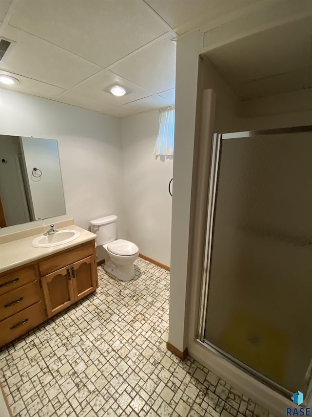 1208 Hampshire Cir, Luverne, MN 56156 - bathroom featuring baseboards, a shower stall, vanity, toilet, and a drop ceiling