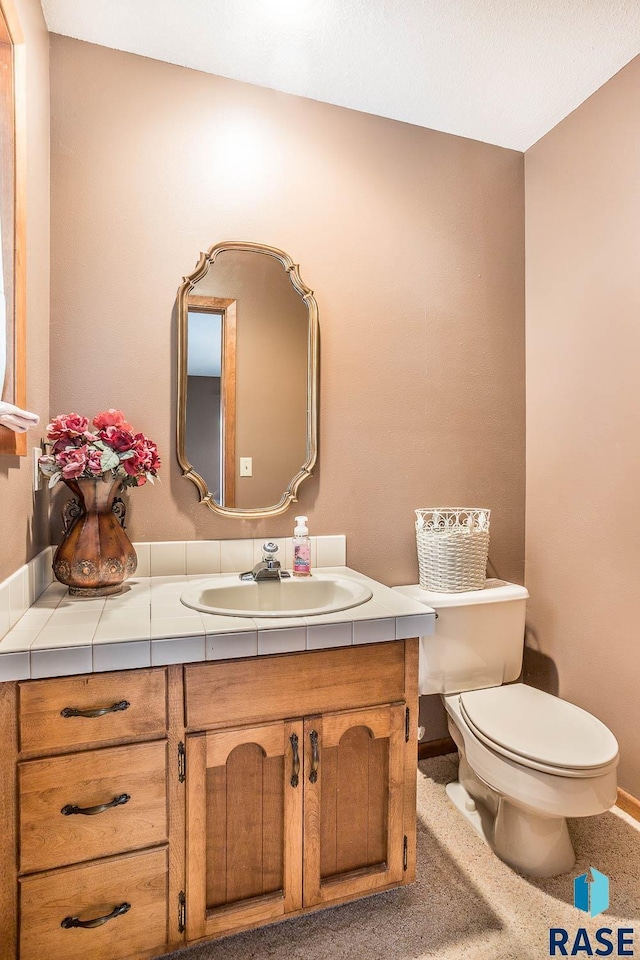 1208 Hampshire Cir, Luverne, MN 56156 - half bathroom featuring toilet, vanity, and baseboards