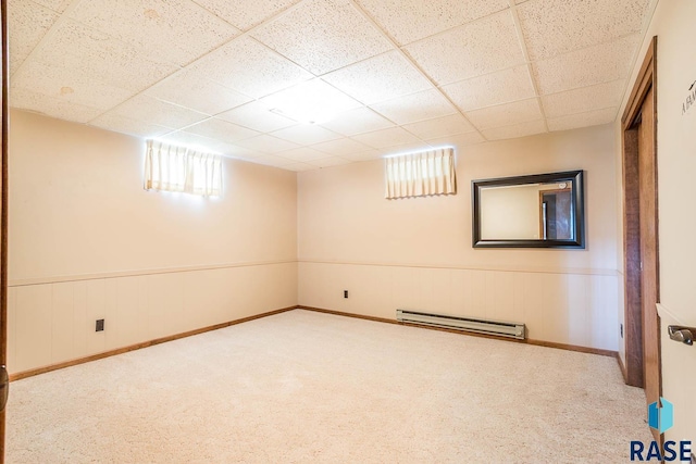 1208 Hampshire Cir, Luverne, MN 56156 - basement featuring baseboard heating, a drop ceiling, carpet, and wainscoting