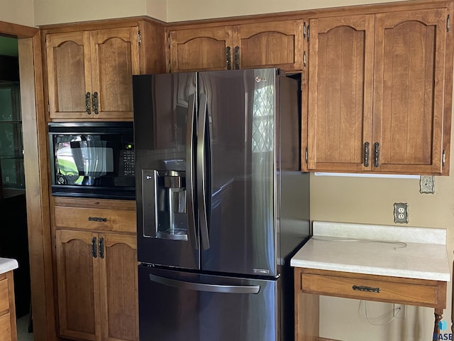 1208 Hampshire Cir, Luverne, MN 56156 - kitchen with stainless steel fridge, black microwave, and brown cabinets