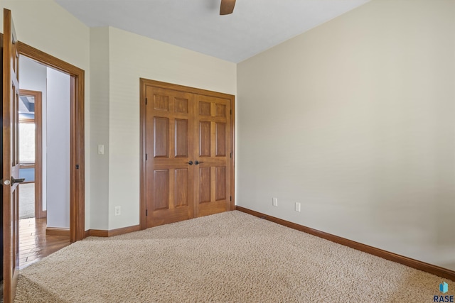 unfurnished bedroom featuring baseboards, carpet, a closet, and ceiling fan