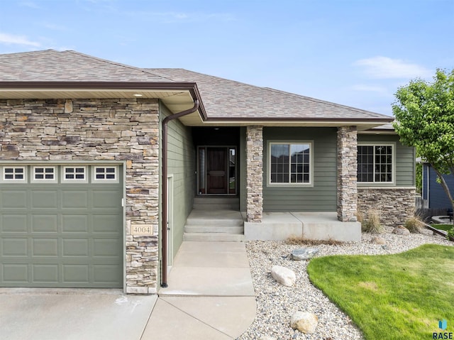 property entrance with stone siding, a shingled roof, and an attached garage