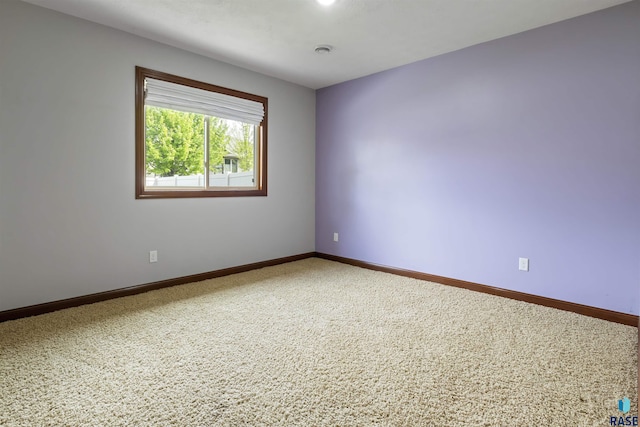 carpeted empty room with baseboards