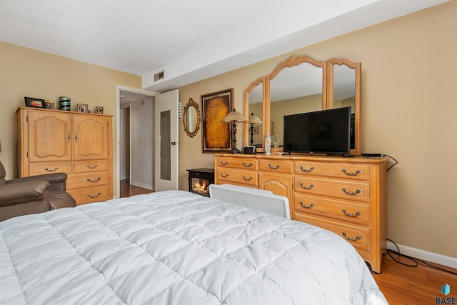 bedroom featuring baseboards and light wood finished floors