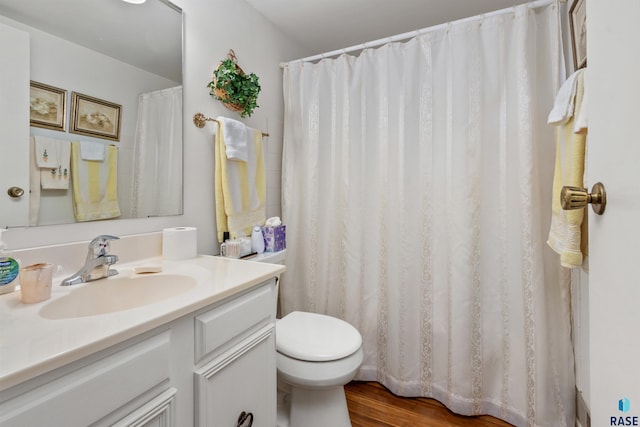 full bath with toilet, vanity, and wood finished floors