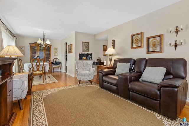 living area featuring a chandelier, wood finished floors, and baseboards