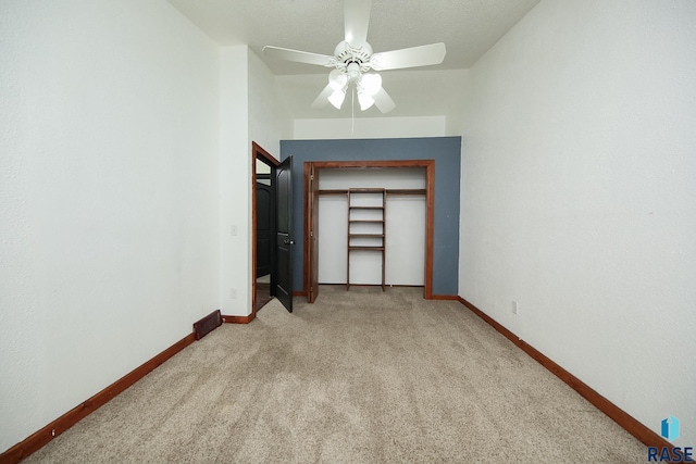 unfurnished bedroom featuring light carpet, baseboards, and ceiling fan